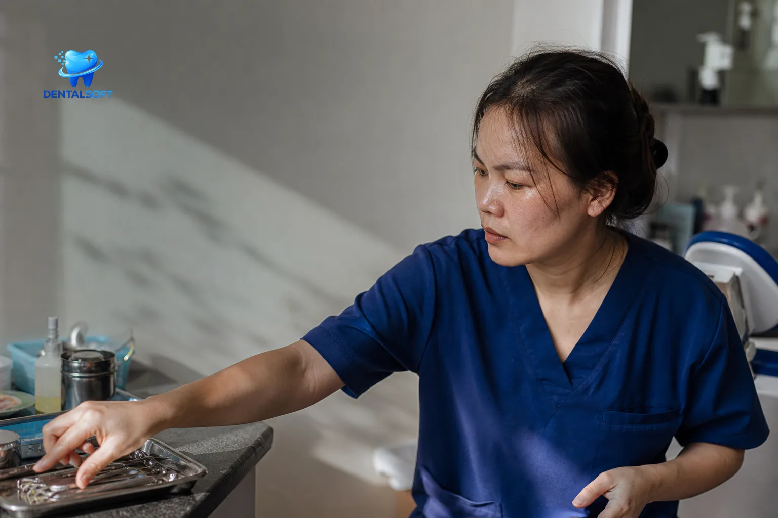 Nhân viên nha khoa đang cẩn thận lấy khay dụng cụ ở quầy phòng khám